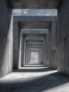 Endless corridor of concrete structures with geometric rectangular frames creating repeating patterns and shadows under a partly Royalty Free Stock Photo
