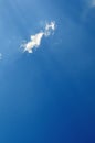 Vaste blue sky with sunrays across little fluffy cloud Royalty Free Stock Photo