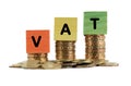 VAT or TAX Concept with colorful wooden block and stacked coins Royalty Free Stock Photo