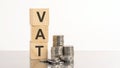 VAT - text on wooden cubes on white background with coins Royalty Free Stock Photo