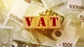 VAT on wooden alphabet cubes with 100 euro banknotes around. Selective focus . Taxes and fees financial concept Royalty Free Stock Photo