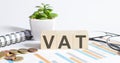 VAT word on the wood blocks concept with chart, coins, notebook and glasses Royalty Free Stock Photo