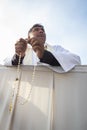 A Priest praying his white holy rosary Royalty Free Stock Photo