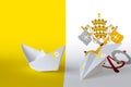 Vatican City State flag depicted on paper origami airplane and boat. Handmade arts concept