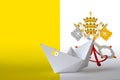 Vatican City State flag depicted on paper origami ship closeup. Handmade arts concept