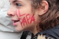 Young italian faithful with 'The Pope' written on the cheek