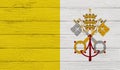 Vatican flag on a wooden texture.