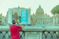 VATICAN, ITALY - JUNE 13, 2015: Unidentified woman taking a photograph with her cellphone to Saint Peter dome Royalty Free Stock Photo