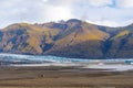 Vatnajoekull glacier in Iceland deep blue ice in front of overgrown mountains Royalty Free Stock Photo