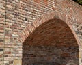 Vault in a wall of burnt bricks. The bricks are arched at an angle to each other. such a niche serves as a place to sit in the gar Royalty Free Stock Photo