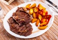 Veal entrecote with baked potatoes and tomato sauce