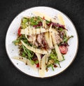 Veal and pear salad with olive-balsamic dressing. Isolated on a black background