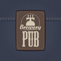 Leather label for brewery or pub on denim backdrop