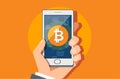 Business man hand holding smartphone with bitcoin icon on screen.