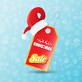 Vector Christmas sales paper banner or tag label with red santa hat on snowy blue background with falling snowflakes Royalty Free Stock Photo