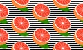 Seamless background with black stripes and half red grapefruit with leaf.