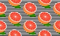 Seamless background with black stripes and half red grapefruit with leaf. Royalty Free Stock Photo