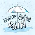 Vector hand drawn lettering quote - enjoy spring rain. With drops and open umbrella