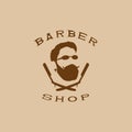 A vector illustration depicting a man`s face with a beard and glasses over two crossed razors. Logo of the men`s hairdresser.