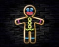 Vector illustration of the gingerbread man neon sign on the black brick background. Cookie in shape of stylized human.