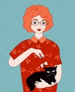 Redheaded girl holding black cat