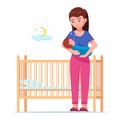 Woman holding a sleeping baby next to a baby crib