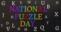 Vector image of national puzzle day text and various alphabets against black background Royalty Free Stock Photo