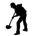Silhouette of a worker in work clothes digging a hole with a shovel from the back