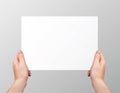 Vector realistic hands holding blank horizontal paper page isolated on grey background