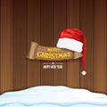 Vector red Santa hat with paper banner and greeting text Merry Christmas and Happy new year on wooden background. Royalty Free Stock Photo