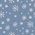 Vector seamless pattern with cartoon hand drawn snowflakes on blue background. Christmas snow pattern Royalty Free Stock Photo