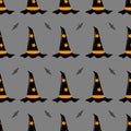 Vector seamless pattern on a Halloween theme. Witch hat and a bat on a gray background.