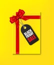 Yellow gift box with red ribbon and bow and tag with Black Friday Sale text Royalty Free Stock Photo