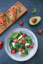 Vediterranean vegetable salad of fresh tomato, olives, capers, onion, spinach, lettuce and sesame on plate. Grillled shrimp Royalty Free Stock Photo