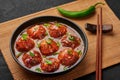 Veg Manchurian Gravy Balls in black bowl in dark slate table top. Vegetarian Manchurian is indian chinese cuisine dish Royalty Free Stock Photo