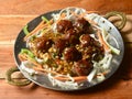 Veg Manchurian, Popular indo-chinese food made of cauliflower florets and other vegetable, served over a rustic wooden table. Royalty Free Stock Photo