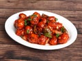 Veg Manchurian, Popular indo-chinese food made of cauliflower florets and other vegetable, served in a white plate over a rustic Royalty Free Stock Photo