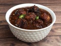 Veg Manchurian, Popular indo-chinese food made of cauliflower florets and other vegetable, served in a white plate over a rustic Royalty Free Stock Photo