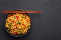 Veg Schezwan Fried Rice in black bowl at dark slate background. indo-chinese cuisine dish