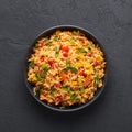 Veg Schezwan Fried Rice in black bowl at dark slate background. indo-chinese cuisine dish