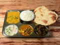 Veg Thali from an indian cuisine, food platter consists variety of veggies, lentils,Chole, steamed rice, roti, bindhi fry, curd,