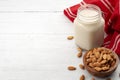 Vegan alternative foods and plant based milks concept with almonds in wooden bowl and creamy almond milk in glass jar isolated on Royalty Free Stock Photo