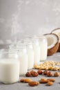 Vegan alternative nut milk in glass bottles on gray background. Royalty Free Stock Photo