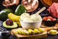 Vegan banana ice cream made with frozen bananas and tropical fruits in the background, without adding chemicals. Healthy dessert