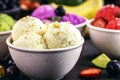 Vegan banana ice cream made with frozen bananas and tropical fruits in the background, without adding chemicals. Healthy dessert