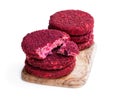 Vegan beetroot and bean burgers on wooden board isolated on white