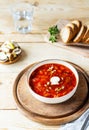 Vegan beetroot soup with mushrooms in a bowl, bread, glass of water on a wooden background Royalty Free Stock Photo
