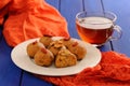 Vegan besan laddu and black tea on deep blue table