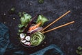 Vegan bowl with chopsticks. Asian salad with rice noodles, carrot, radish and cucumber on black background. Top view Royalty Free Stock Photo