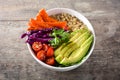 Vegan Buddha bowl with fresh raw vegetables and quinoa on wood Royalty Free Stock Photo